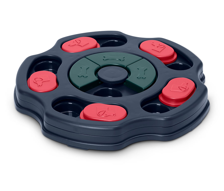 Interaktywna zabawka dla psa z mechanizmem obrotowym, czerwonymi pokrywkami i zielonymi kośćmi.