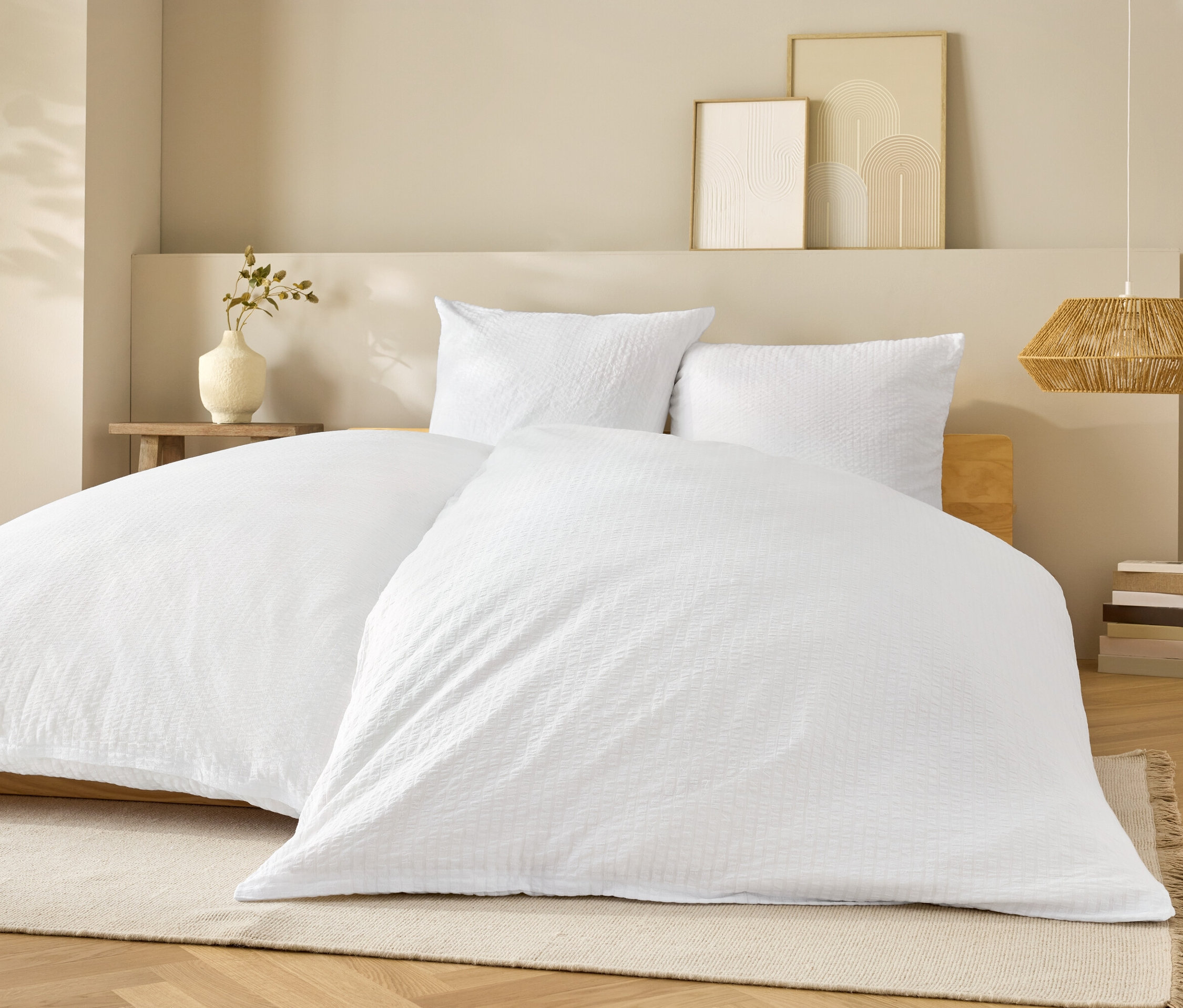 Biała pościel na łóżku z białymi poduszkami.