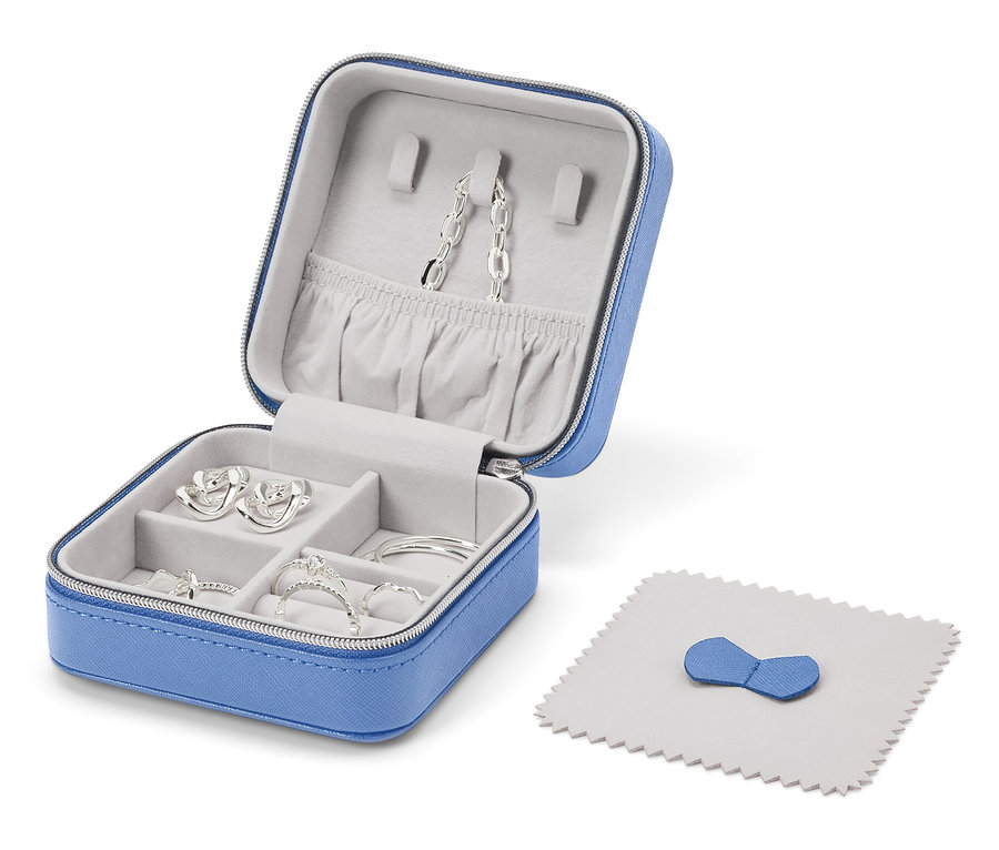 Otwarta niebieska szkatułka na biżuterię ze srebrną biżuterią i ściereczką do polerowania.