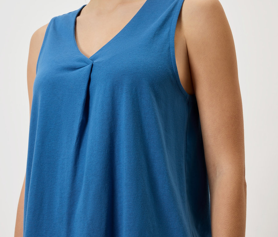 Zbliżenie kobiety w niebieskim topie bez rękawów.