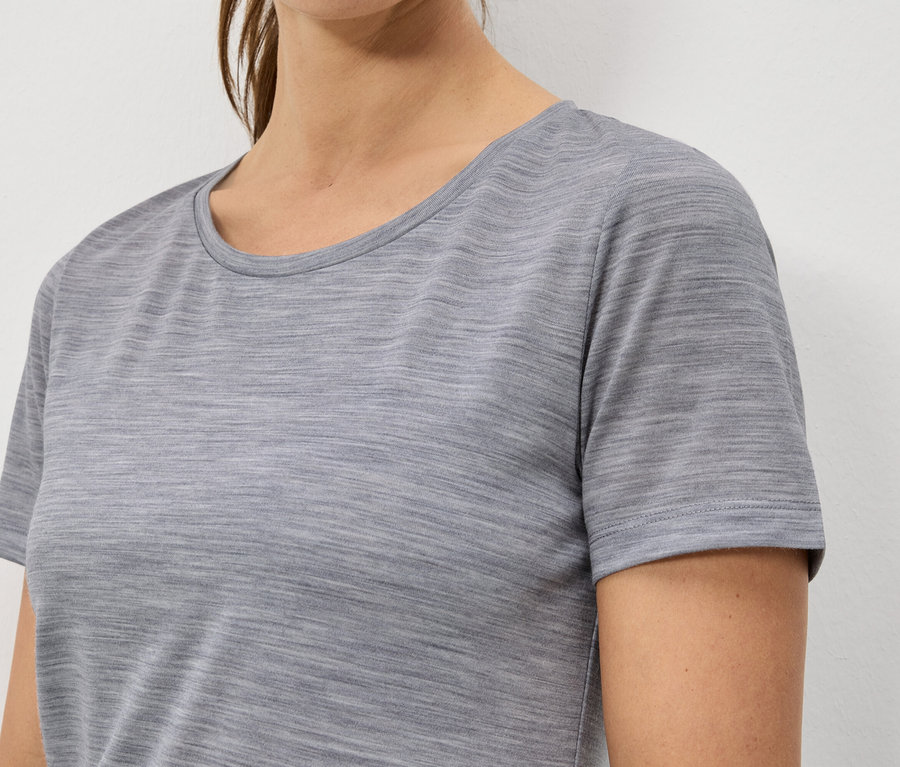 Zbliżenie kobiety w melanżowym, szarym T-shircie z krótkim rękawem.