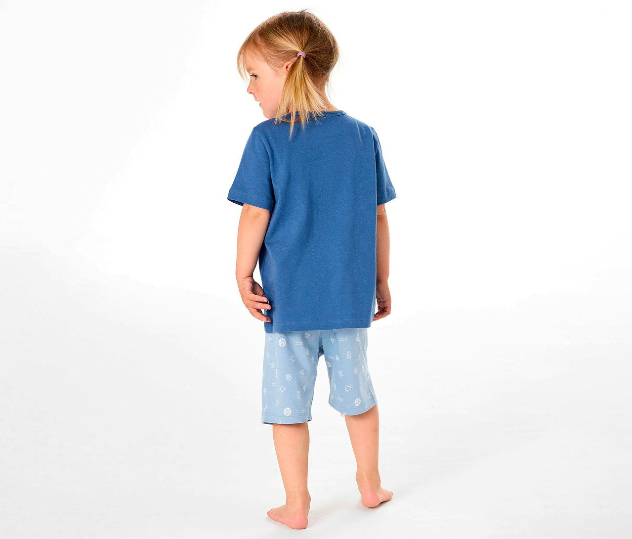 Z tyłu widać dziewczynkę w krótkiej piżamie dziecięcej SCHIESSER.