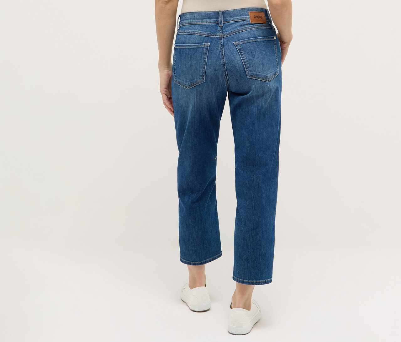 Widok z tyłu na kobietę w niebieskich dżinsach Angels „Evi” i białych butach.
