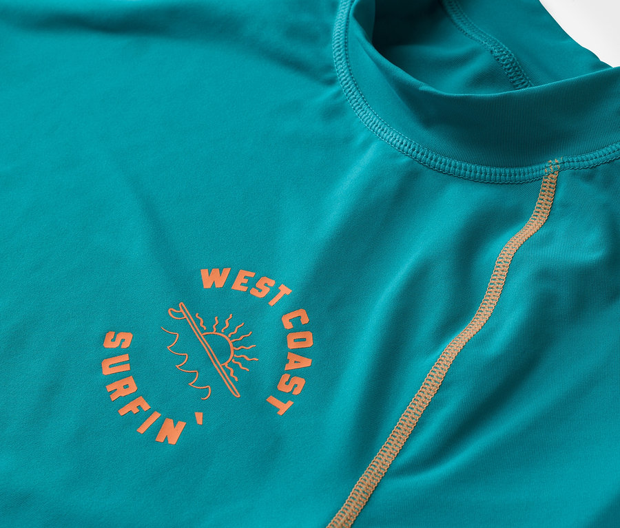 Zdjęcie z bliska turkusowej koszulki z długim rękawem z pomarańczowym logo "West Coast Surfin".