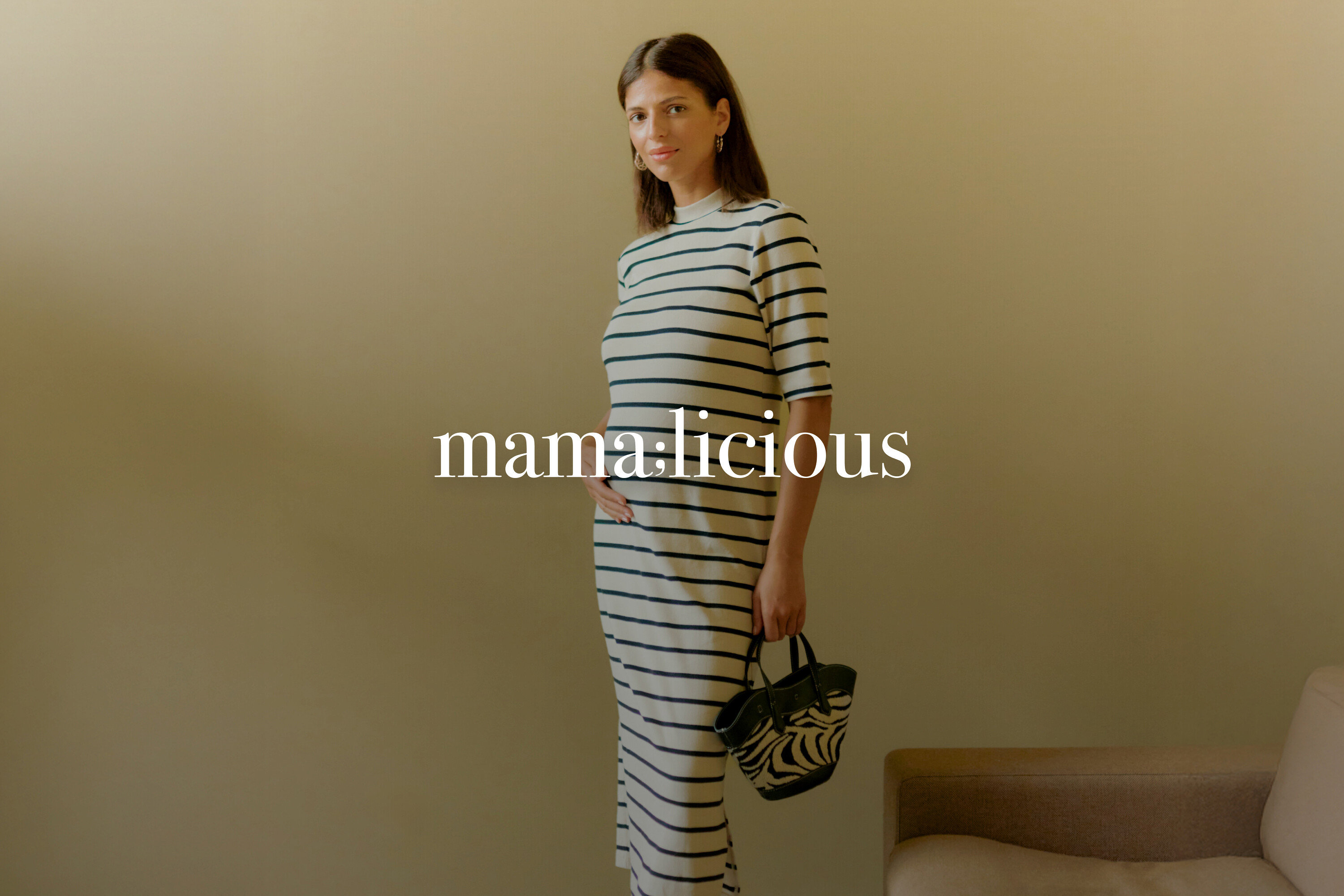 Kobieta w ciąży ma na sobie sukienkę w paski i trzyma torebkę w zebrę.