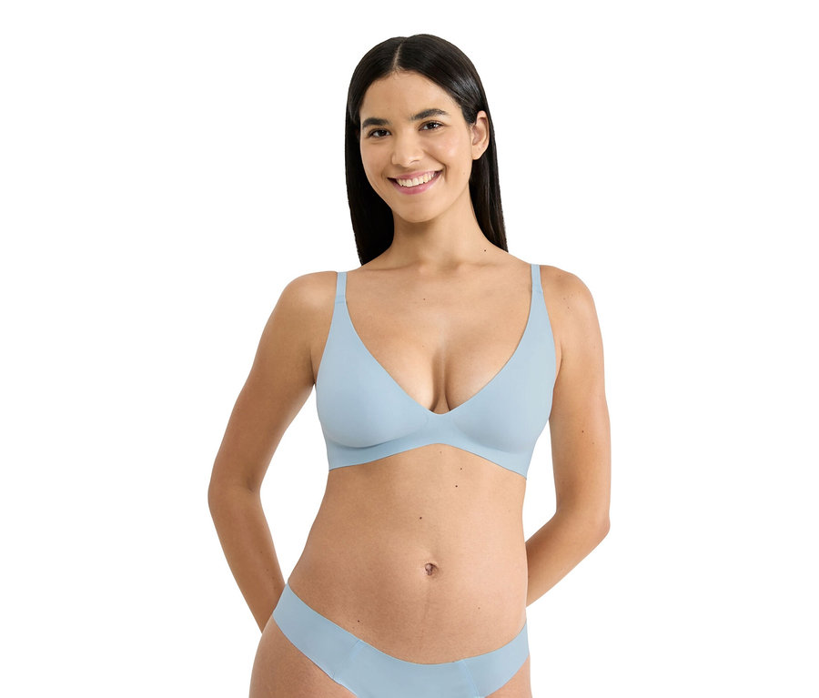 Kobieta o ciemnych włosach ma na sobie jasnoniebieski biustonosz i pasującą bieliznę.