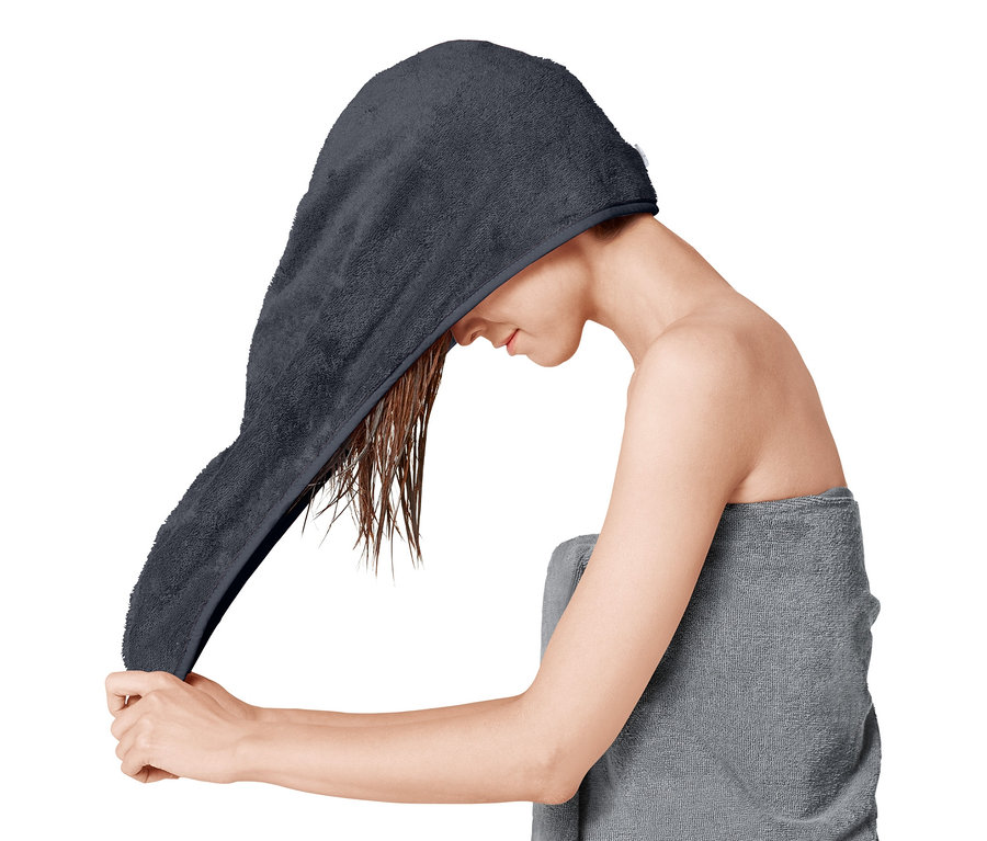 Kobieta zakłada turban do włosów na mokre włosy.