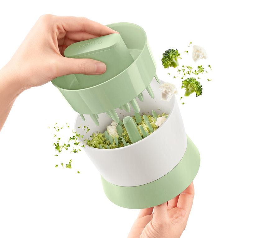 Osoba używa rozdrabniacza do warzyw.