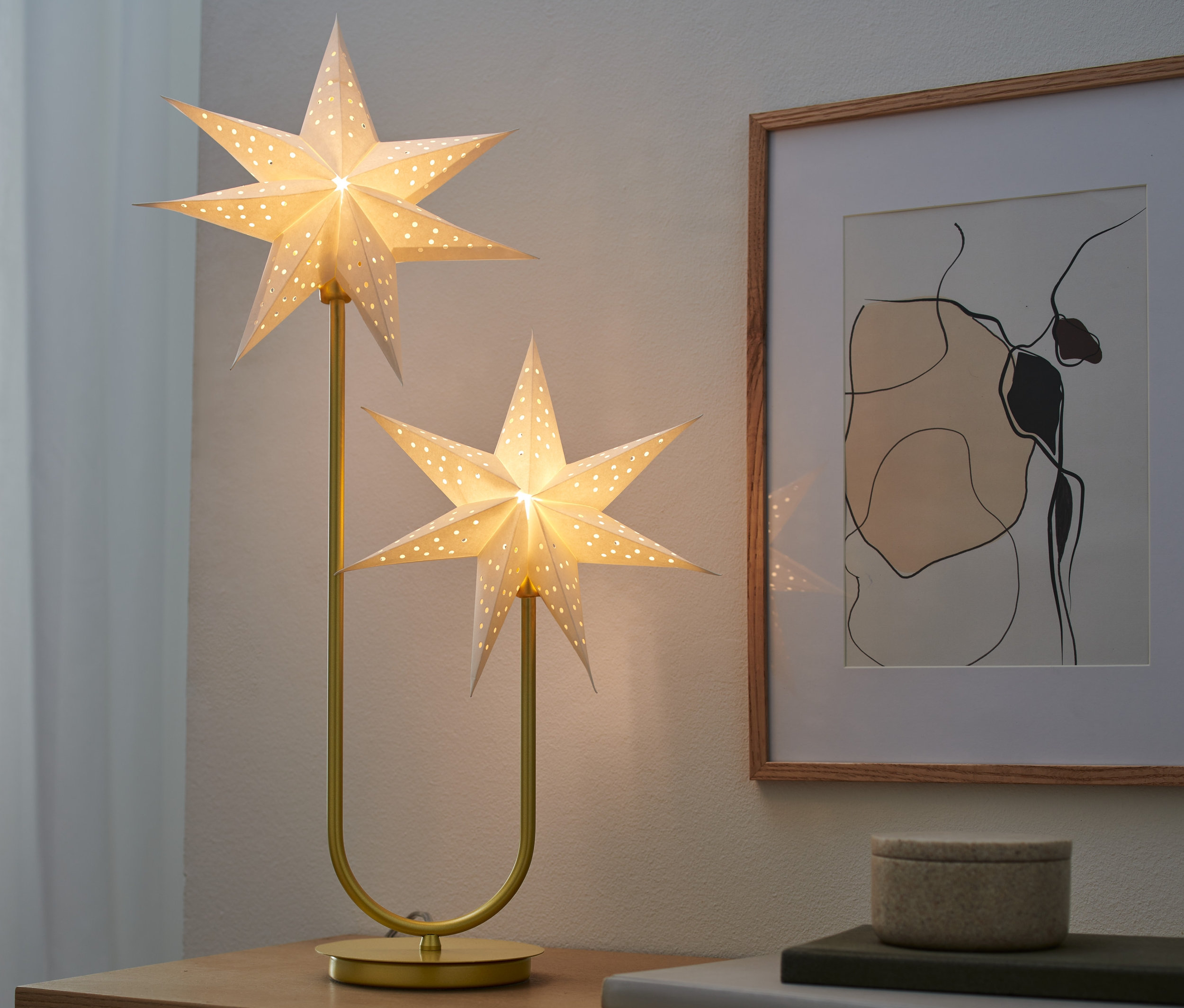 Lampa dekoracyjna LED »Gwiazdy« na stole obok ramki na zdjęcia.
