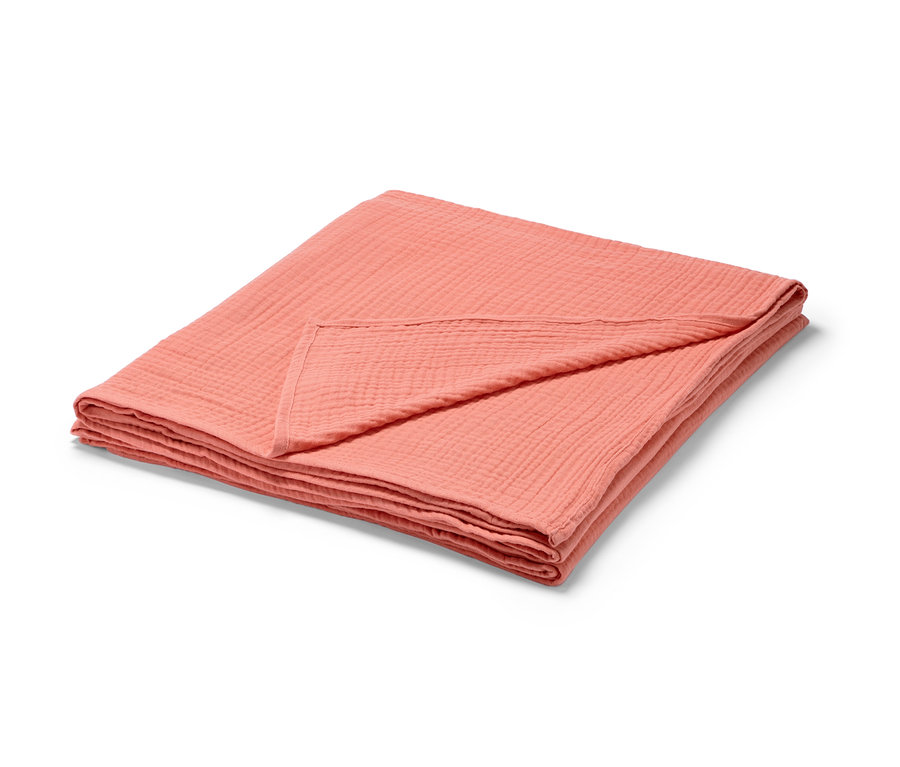 Złożona brzoskwiniowa narzuta muślinowa.