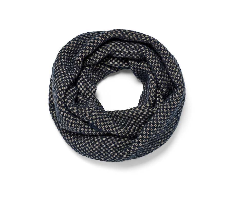 Zbliżenie na komin z dzianiny w kolorze granatowym i beżowym.