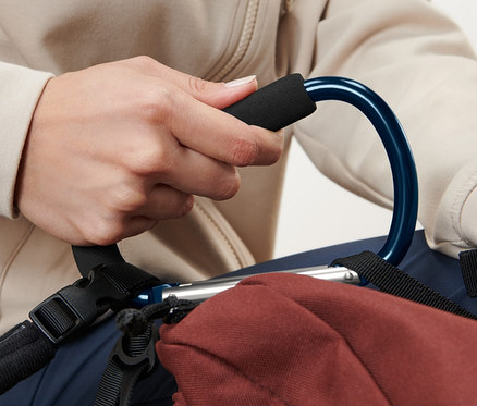 Osoba trzyma niebieski karabińczyk XXL, 2 sztuki, przymocowany do brązowego plecaka.