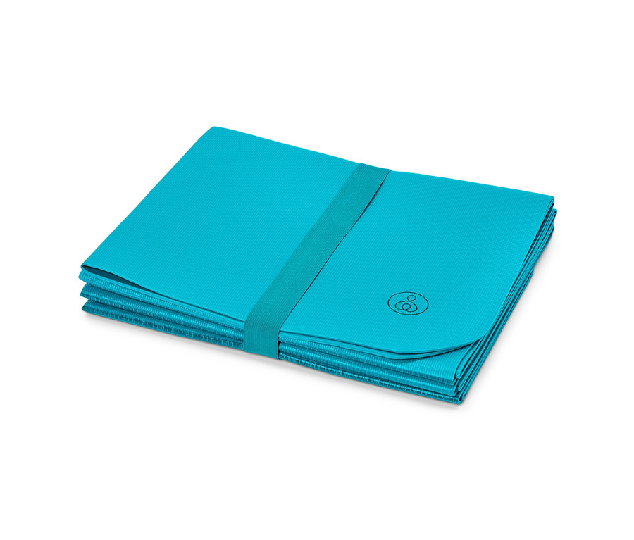 Składana podróżna mata sportowa złożona w prostokąt i zabezpieczona elastyczną taśmą.
