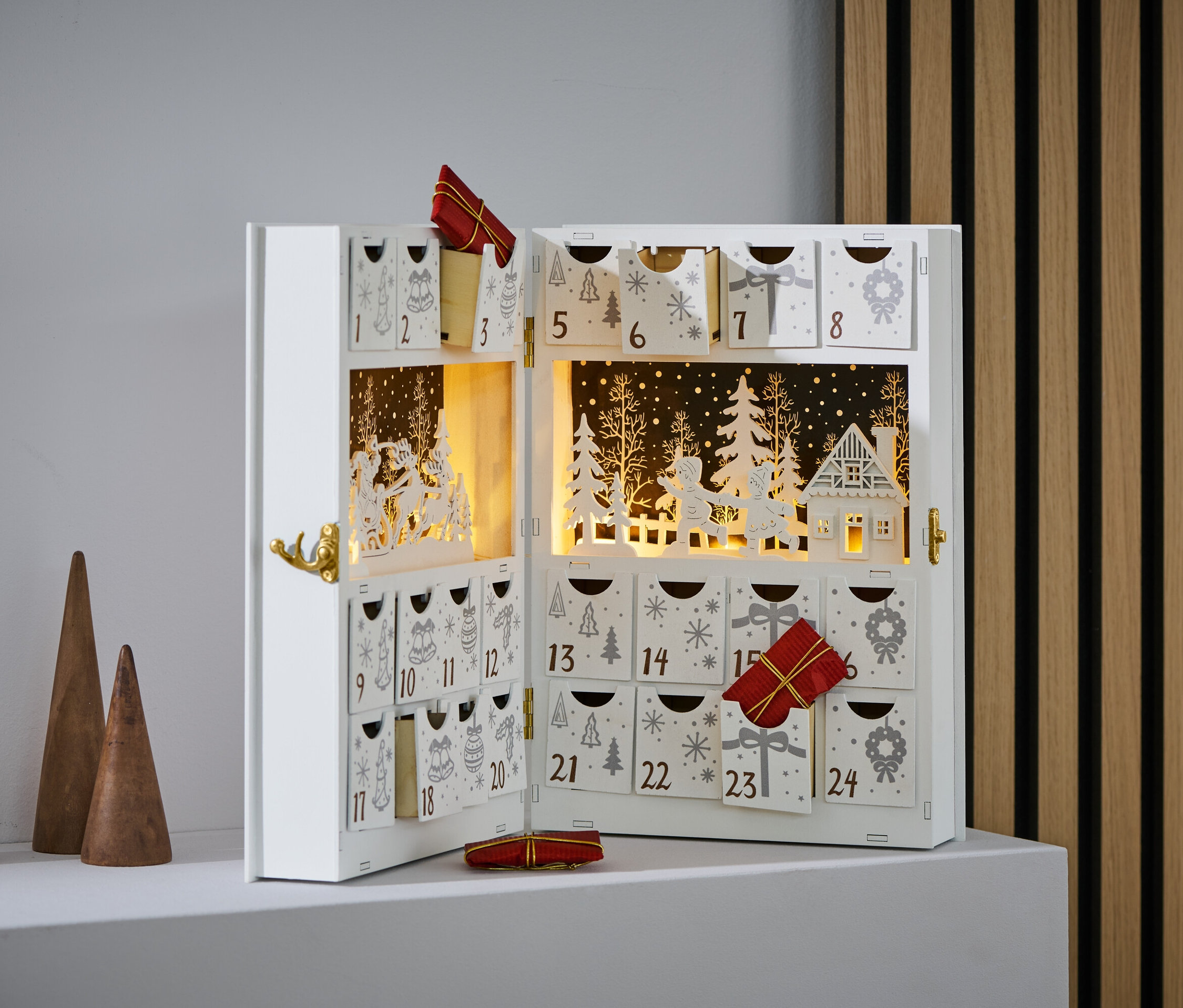 Otwarty kalendarz adwentowy LED z małymi prezentami w niektórych przegródkach.