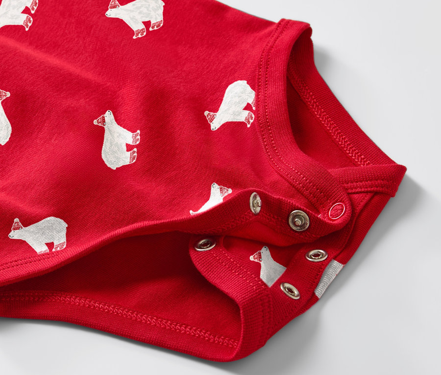 Zbliżenie na czerwone body dziecięce z długim rękawem, w białe niedźwiedzie polarne.