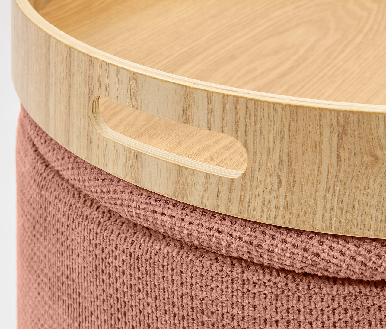 Szczegół drewnianej tacy z uchwytami na dzierganym taborecie.