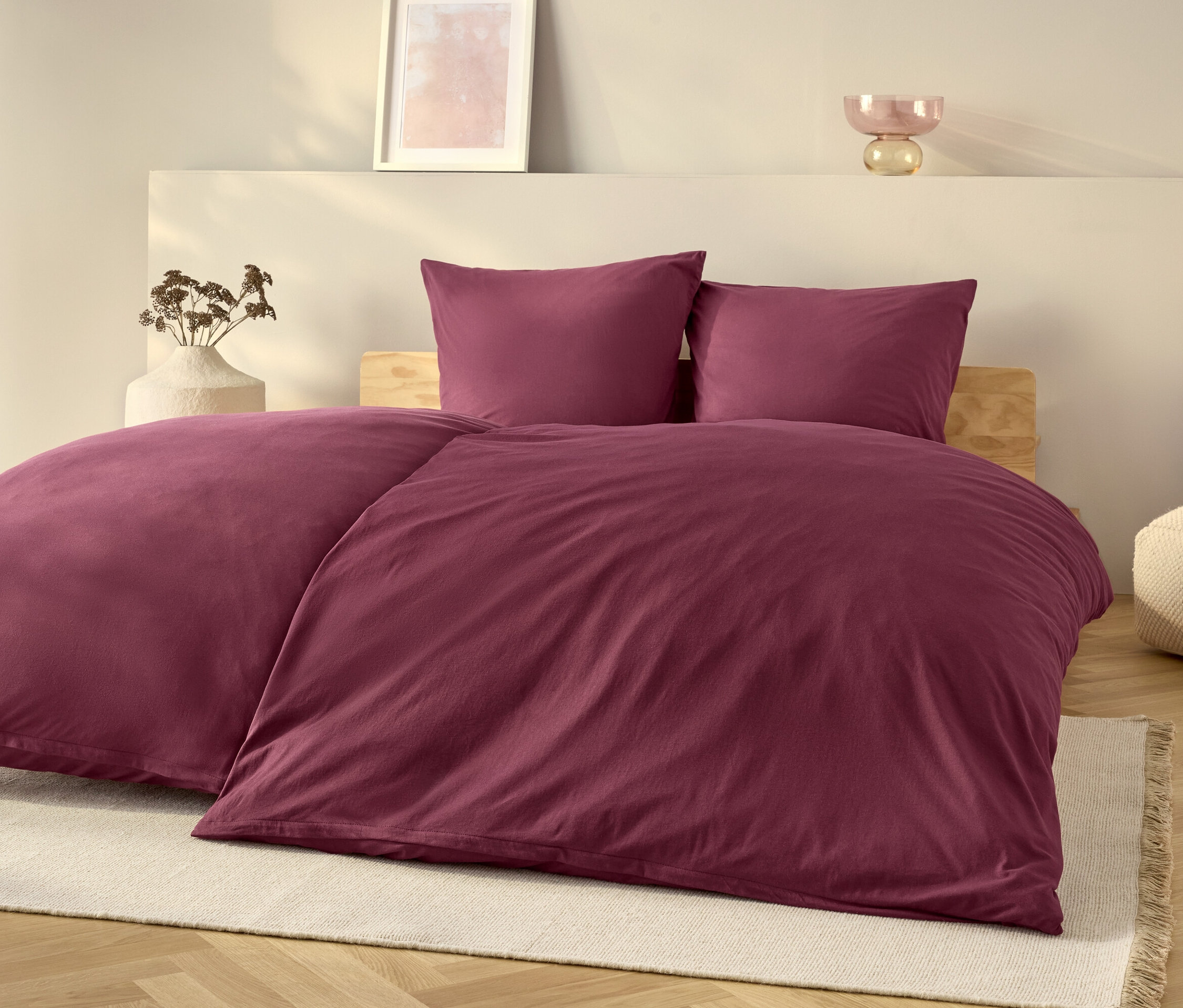 Fioletowy zestaw pościeli na łóżku z białym dywanem.