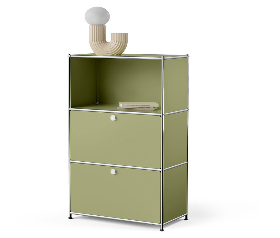 Zielona szafka z dwiema szufladami i otwartą górną półką, na której leży książka i stoi ozdobna lampa.