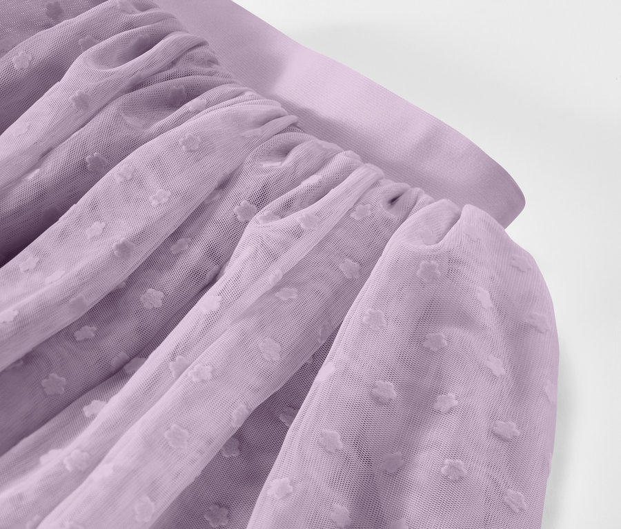 Zbliżenie na marszczoną, lawendową tkaninę tiulową w kropki.