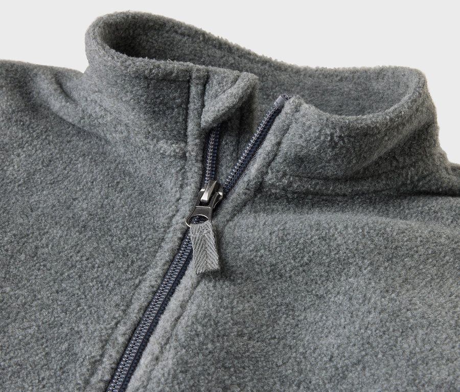 Zbliżenie na szary pajacyk niemowlęcy z polaru z rozpiętym zamkiem błyskawicznym.