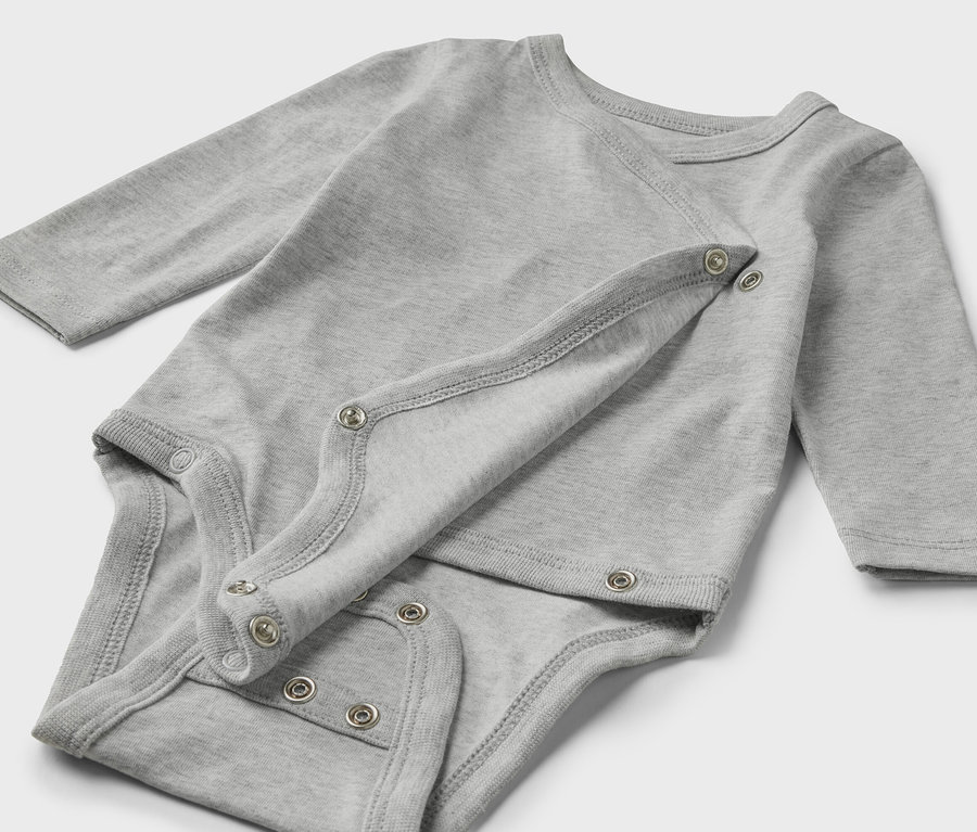 Szary zestaw pięciu body dla niemowląt leży na jasnym tle.