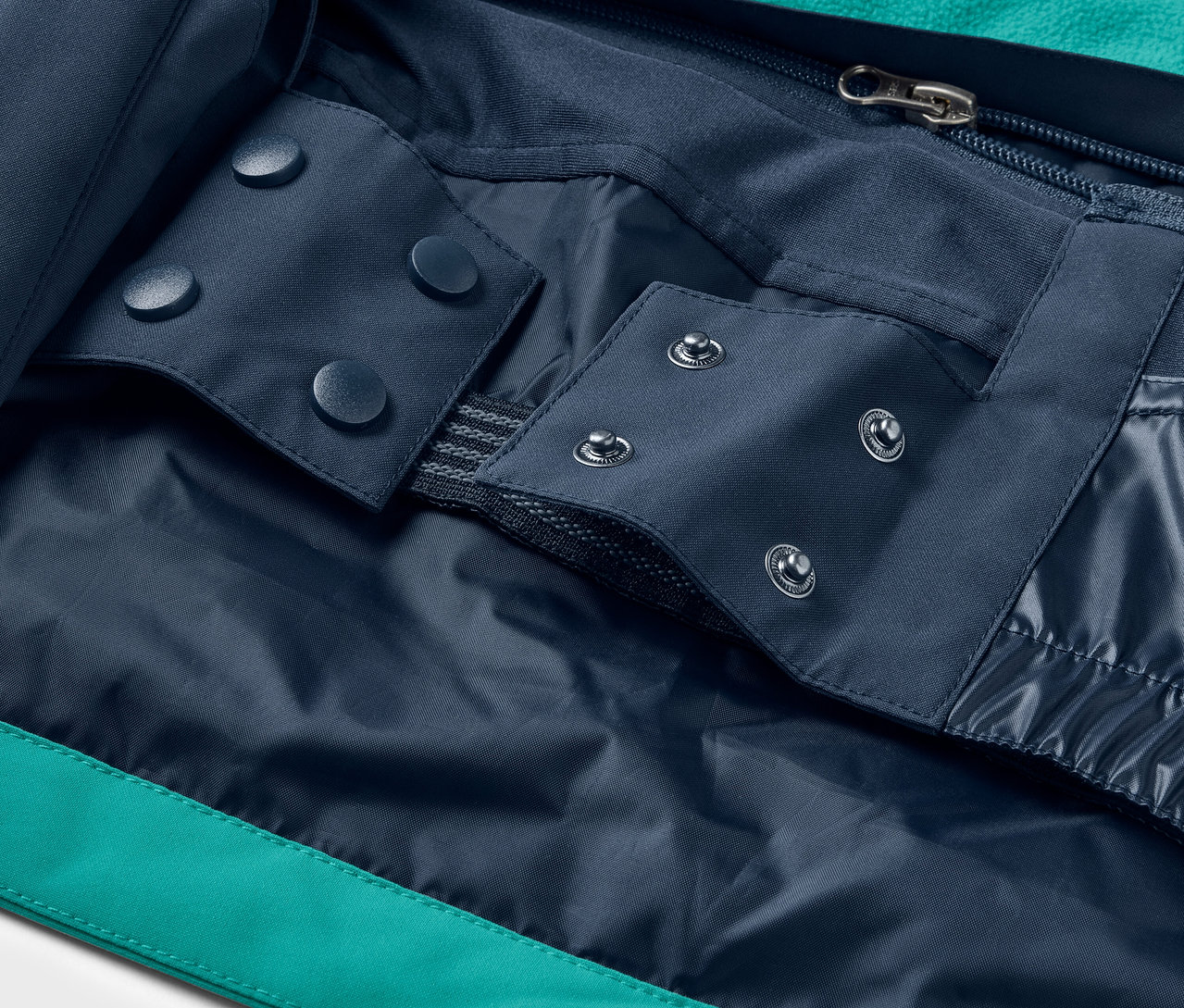 Detal kurtki z niebieskimi zatrzaskami i zamkiem błyskawicznym.