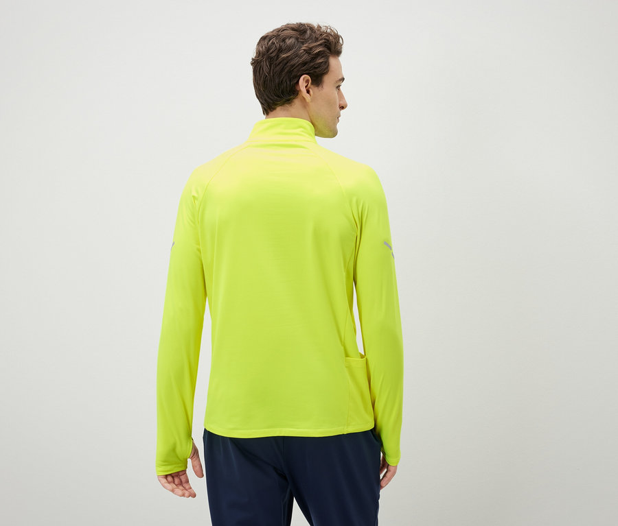 Mężczyzna tyłem do kamery ma na sobie neonowożółtą bluzę sportową z długim rękawem.