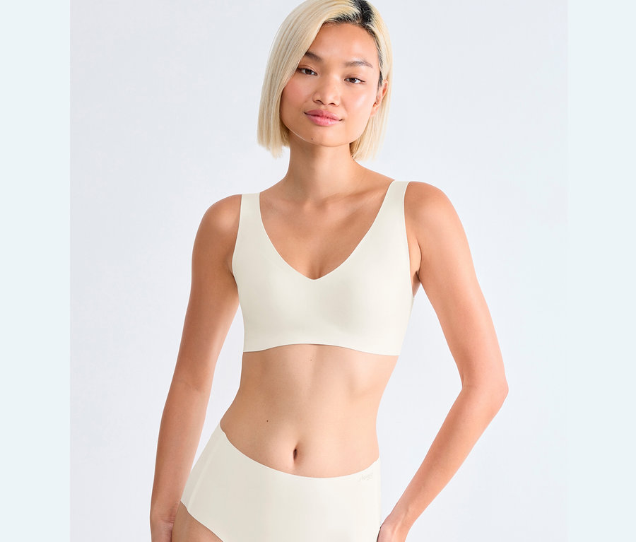 Kobieta ma na sobie biustonosz bralette sloggi ZERO Feel 2.0 w kolorze jedwabista biel.