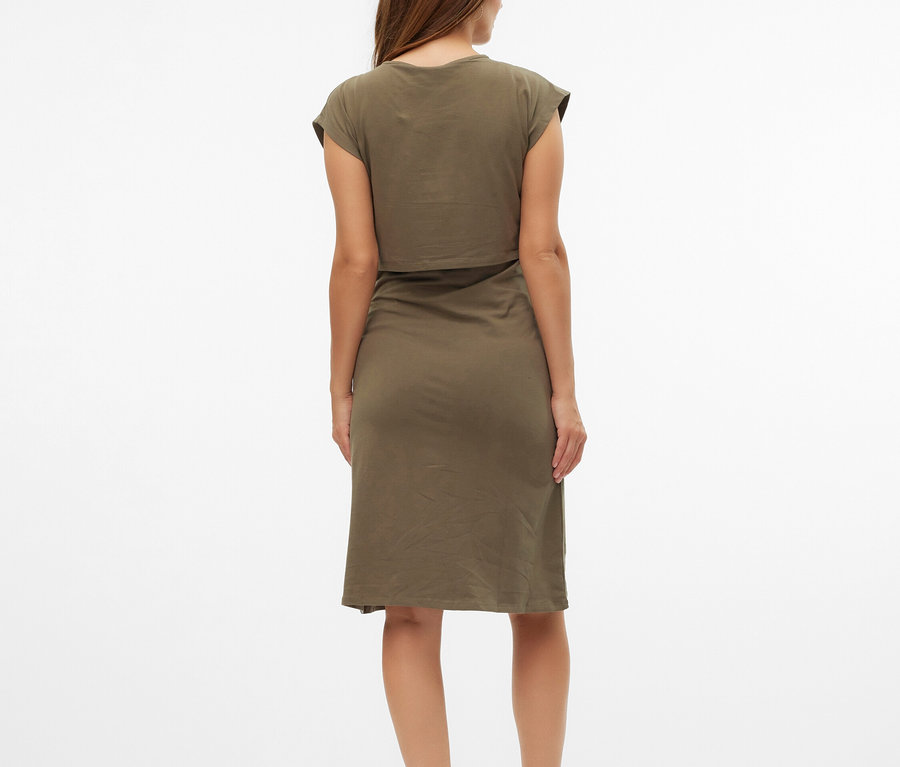 Kobieta widziana od tyłu w oliwkowej sukience typu T-shirt i beżowych sandałach.