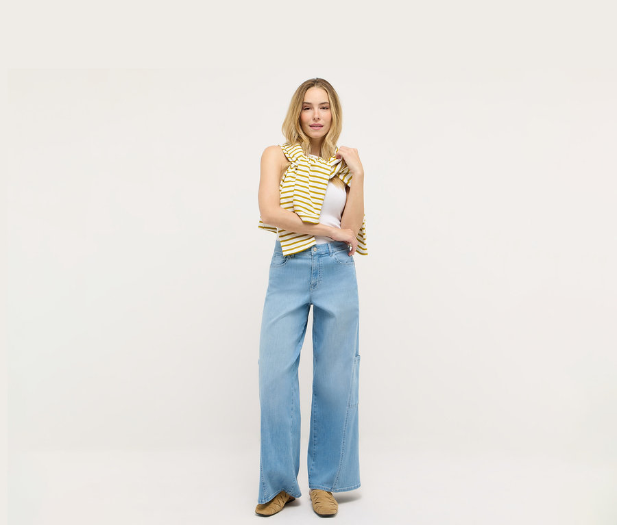 Kobieta stoi na białym tle i ma na sobie dżinsy Angels „Liva” Cargo Wide Leg.