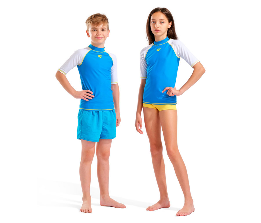 Chłopiec i dziewczynka stoją boso na białym tle, oboje w niebiesko-białych topach i kąpielówkach.