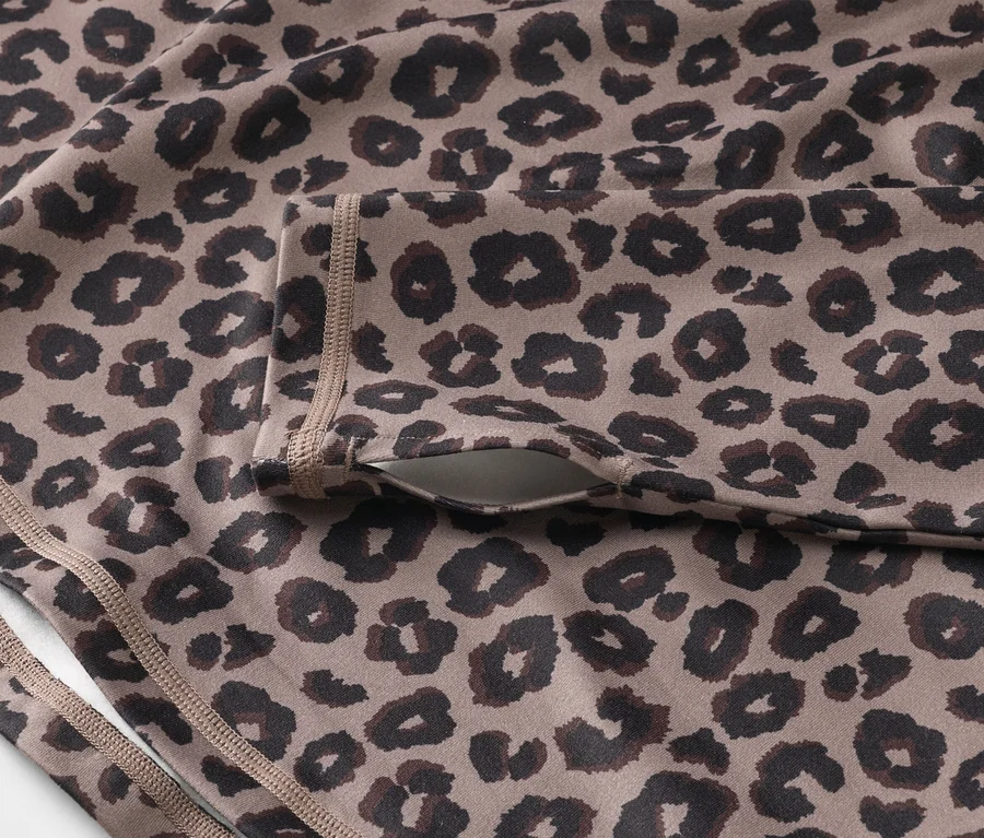 Zbliżenie na sportową bluzkę z motywem leoparda i kieszenią na rękawie.