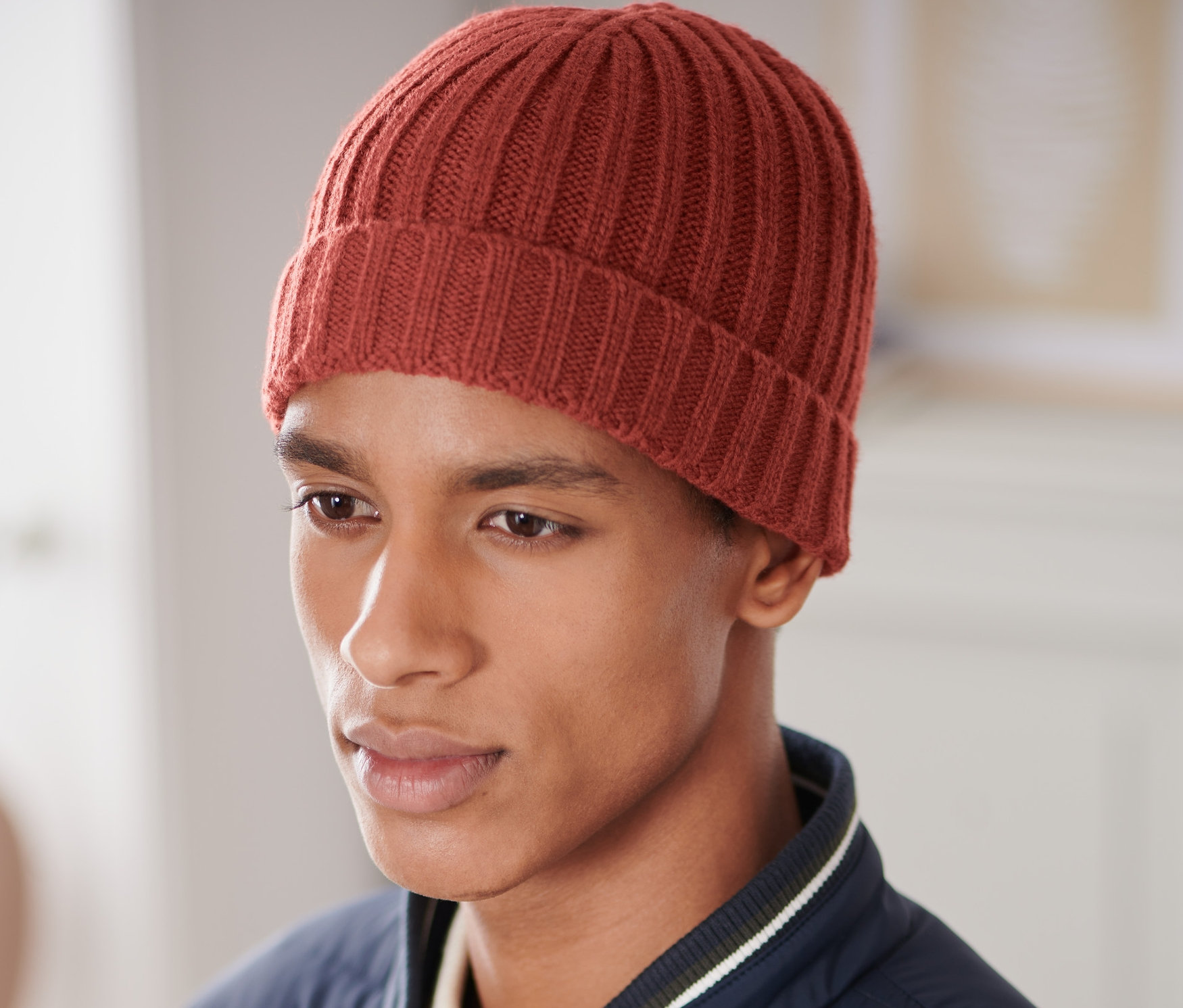 Mężczyzna ma na sobie czapkę z dzianiny.