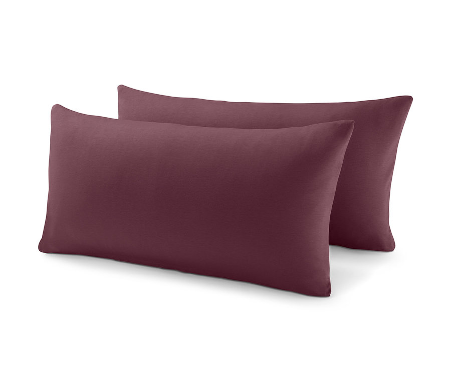 Dwie bordowe poduszki leżą na sobie.
