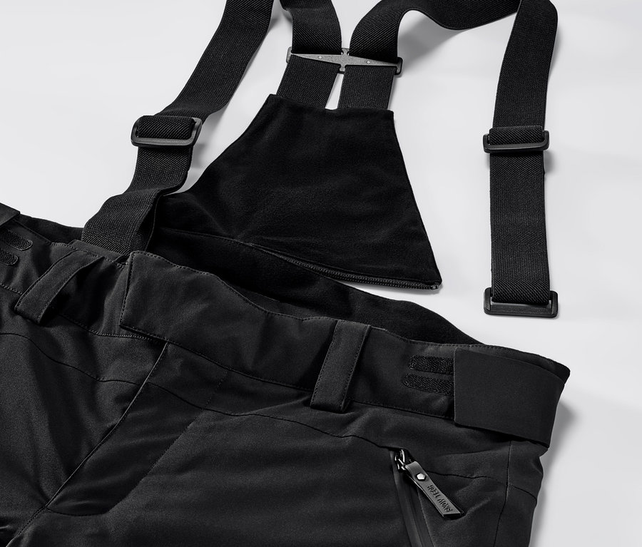 Szczegółowe ujęcie czarnych, profesjonalnych spodni narciarskich z szelkami.