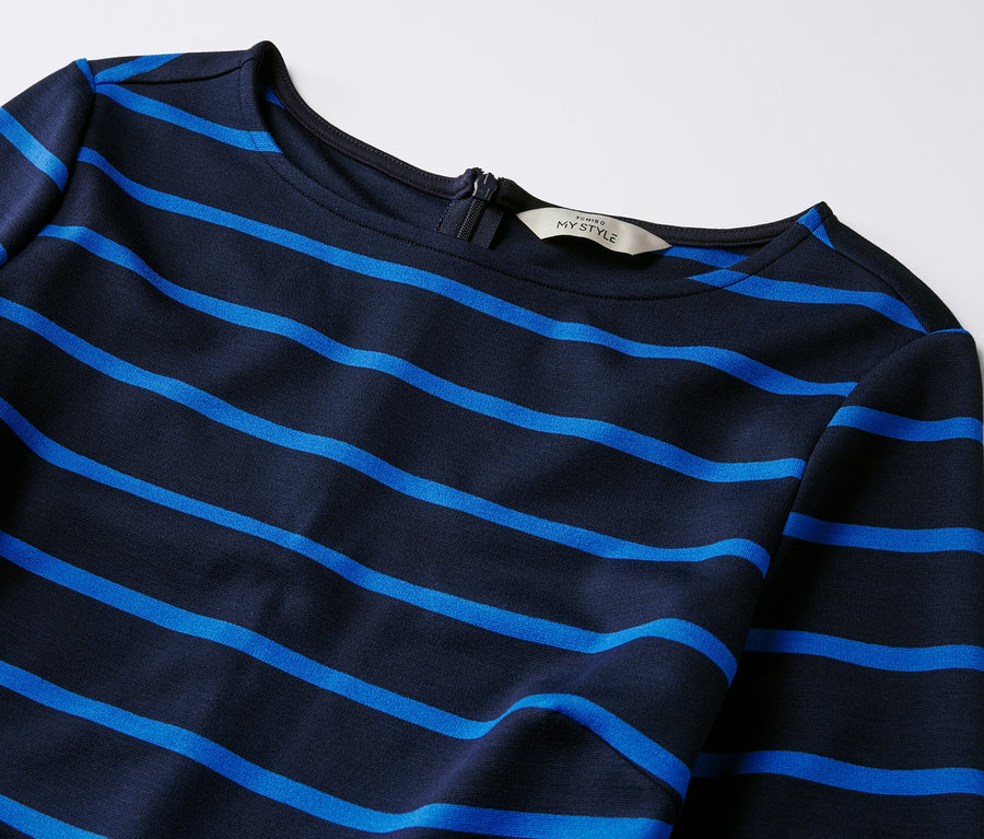 Zbliżenie na dżersejową sukienkę w paski.