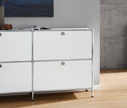 Salon z białą szafką typu sideboard »CN3« z 6 klapami, antracytową sofą 3-osobową, białą lampą stołową z kloszem z tkaniny i białym stolikiem na kółkach »CN3«.
