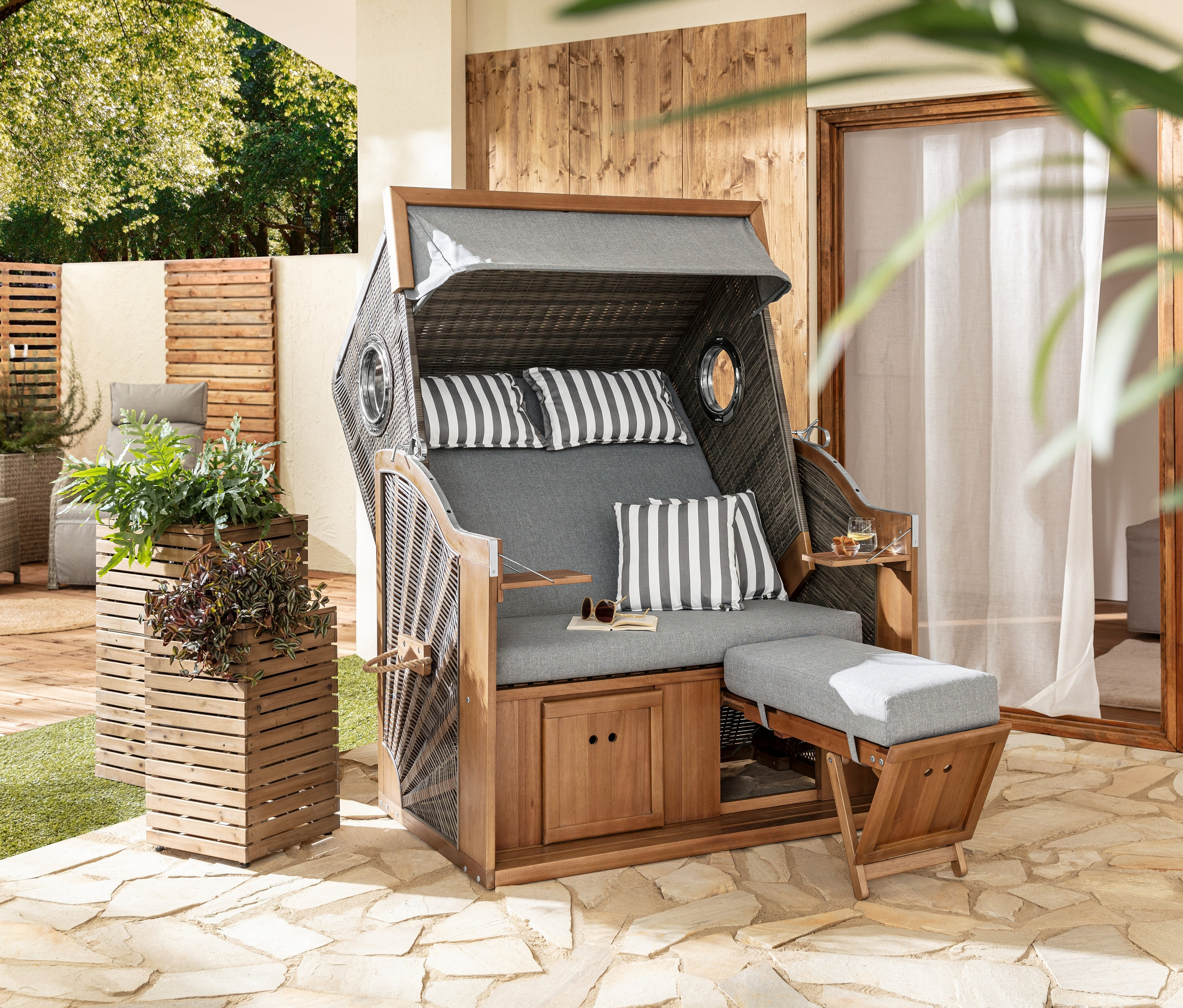 Dwie donice »Tinus« stoją obok kosza plażowego Premium XL z dwoma rozkładanymi stolikami.