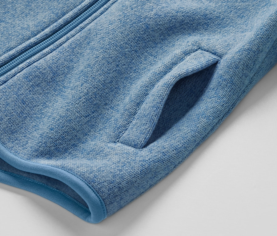 Zbliżenie na bluzę z dzianiny polarowej z kieszenią i zamkiem błyskawicznym.