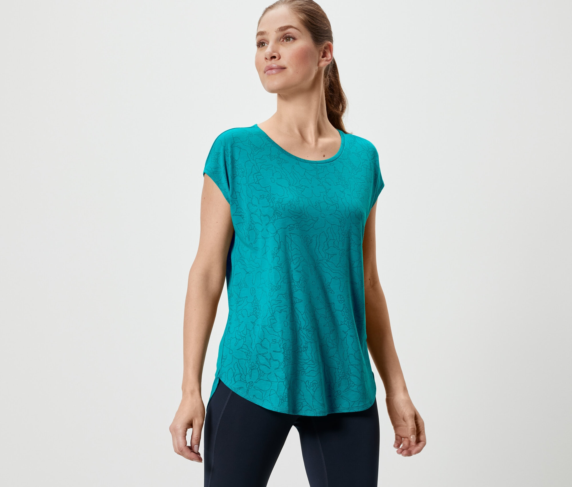 Kobieta ma na sobie turkusową koszulkę sportową.