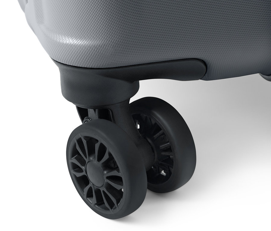 Zbliżenie na szarą, dużą walizkę z twardą skorupą wykonaną z recyklingu.