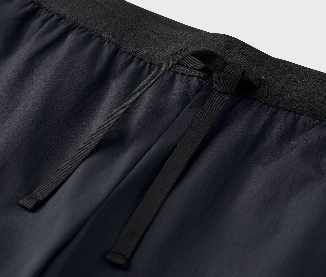 Zbliżenie na czarne spodnie funkcjonalne ze sznurkiem.