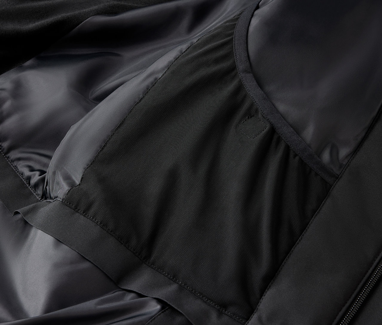 Zbliżenie na czarną kurtkę z wewnętrzną kieszenią.