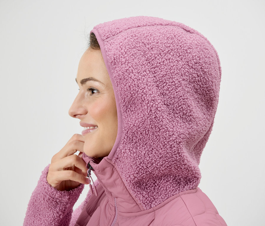 Kobieta w różowej kurtce z kapturem.