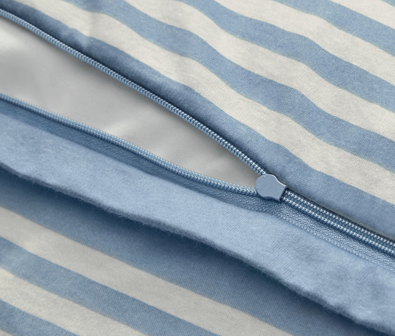 Szczegółowy widok pościeli zimowej jersey w standardowym rozmiarze z niebiesko-białymi paskami i zamkiem błyskawicznym.