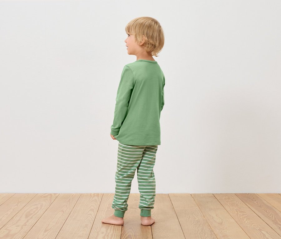 Chłopiec w zielonej piżamie patrzy w lewo.