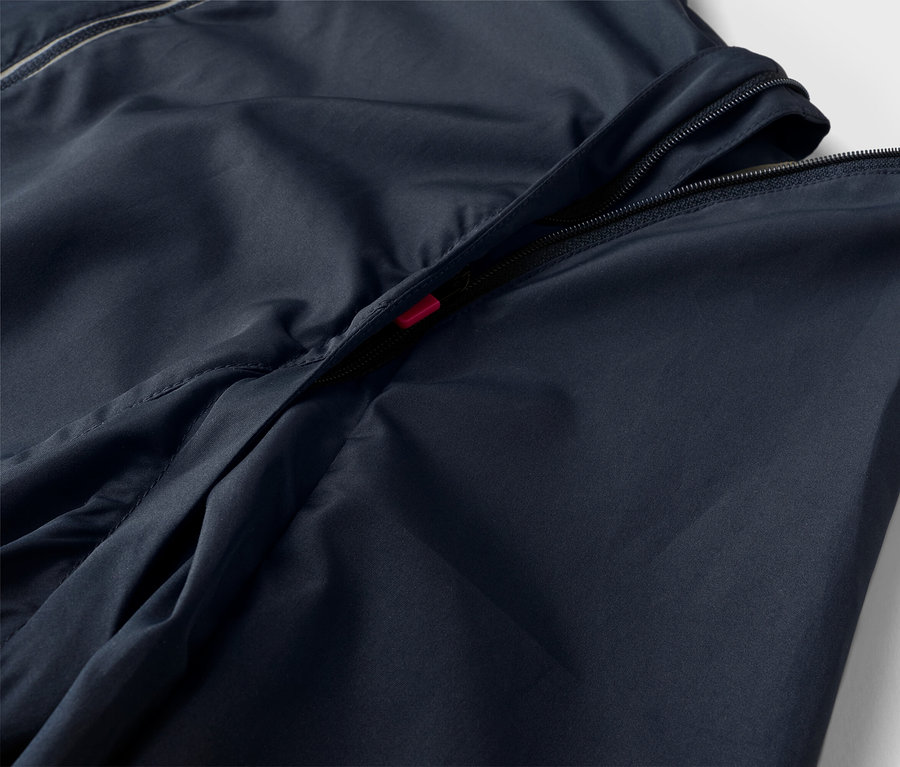 Zbliżenie granatowej kurtki z częściowo otwartym zamkiem błyskawicznym.