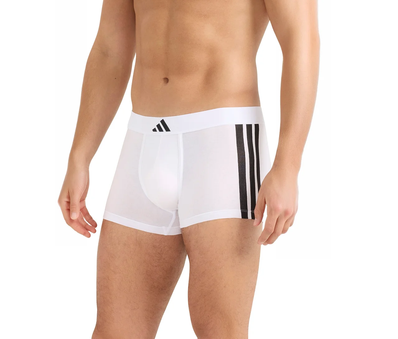 Mężczyzna w białych bokserkach z czarnym logo Adidas na pasie i trzema czarnymi paskami z boku.