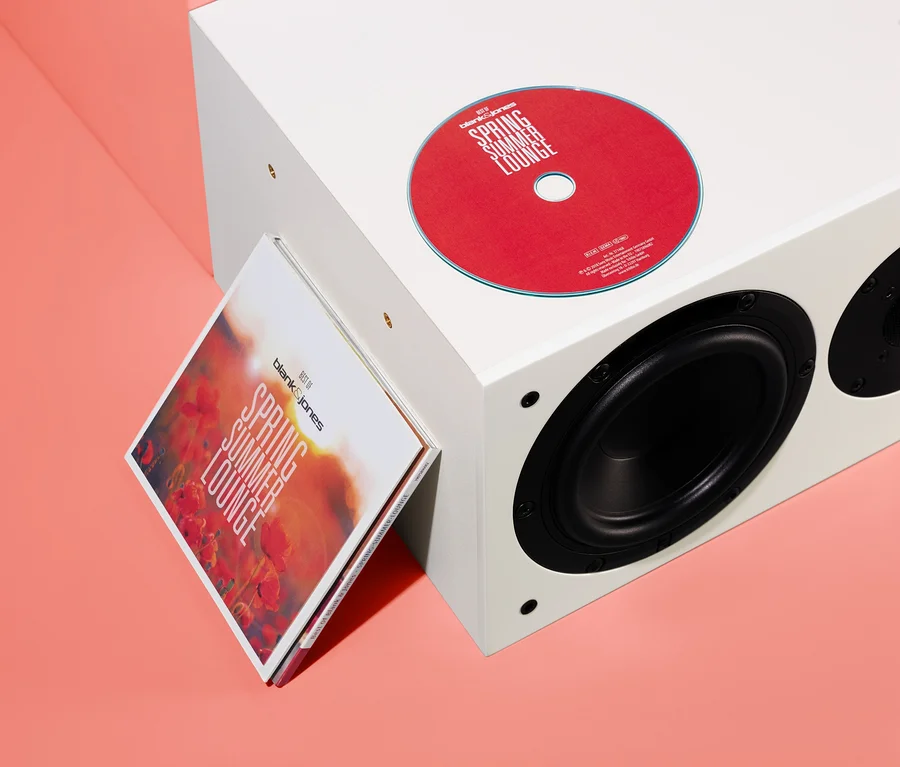 Czerwona płyta CD i okładka albumu »Best of Blank & Jones: Spring Summer Lounge« oparte o biały głośnik.