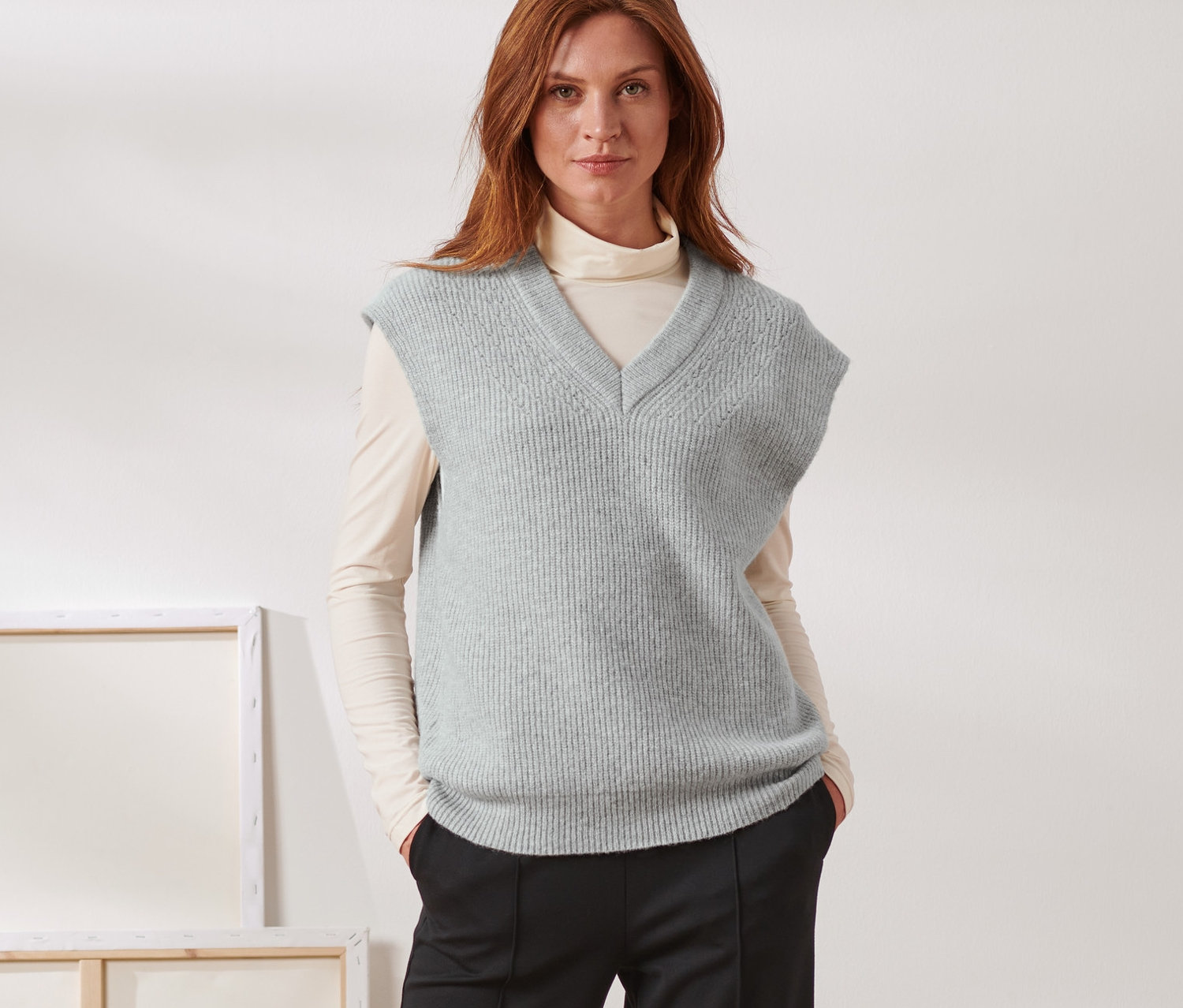 Kobieta pozuje w kamizelce dzianinowej z wełną.